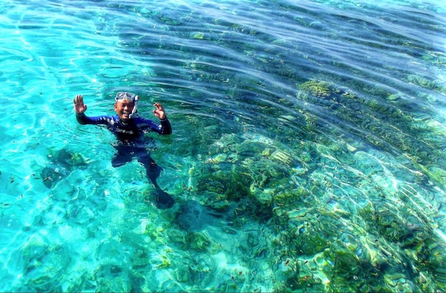 海でスノーケルで泳いでいる男の高角度の写真