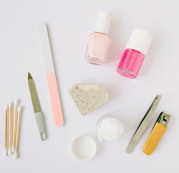 High angle view of manicure tools and products on white backdrop