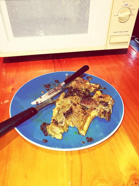 High angle view of meat in plate on wooden table