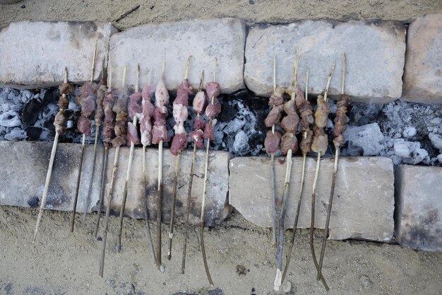 High angle view of meat in skewer on coal