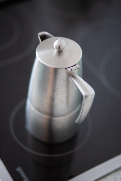 Photo high angle view of metallic jug on stove at home
