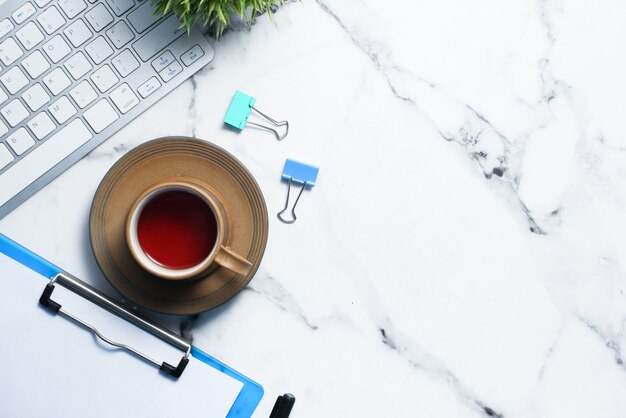 Veduta dall'alto del posto di lavoro moderno con una tazza di tè,