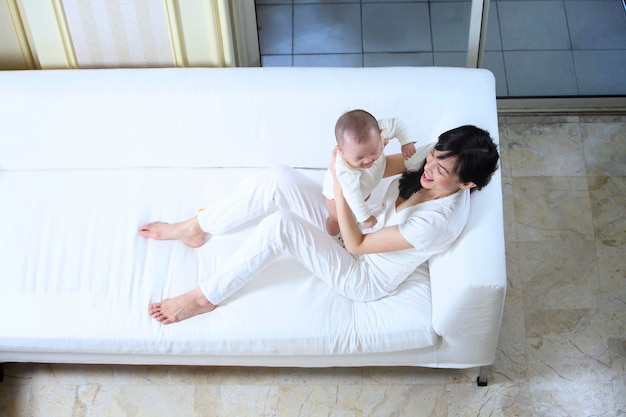 High angle view of mother and baby on sofa at home