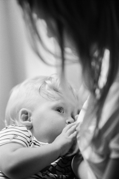 High angle view of mother breastfeeding baby girl at home