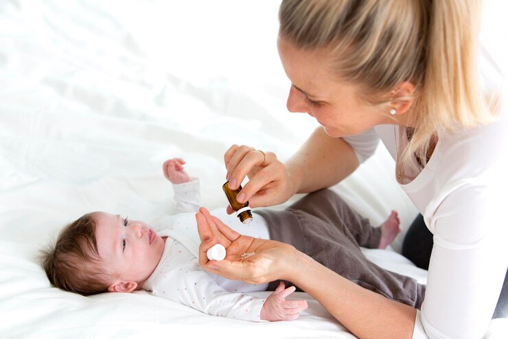 Photo high angle view of mother giving pills to baby lying on bed at home
