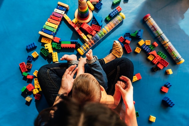 High angle view of mother holding boy playing with toys at home