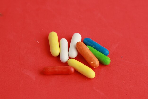 Photo high angle view of multi colored candies on red background