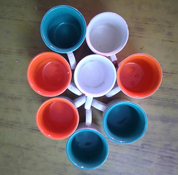 High angle view of multi colored cups on table