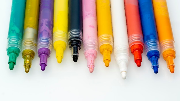Высокоугольный вид многоцветных ручек на белом фоне
