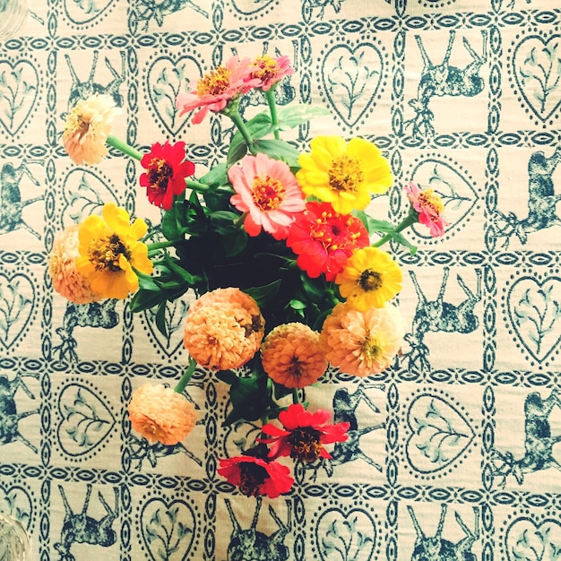 Foto vista ad alto angolo di un vaso di fiori multicolore in tavola
