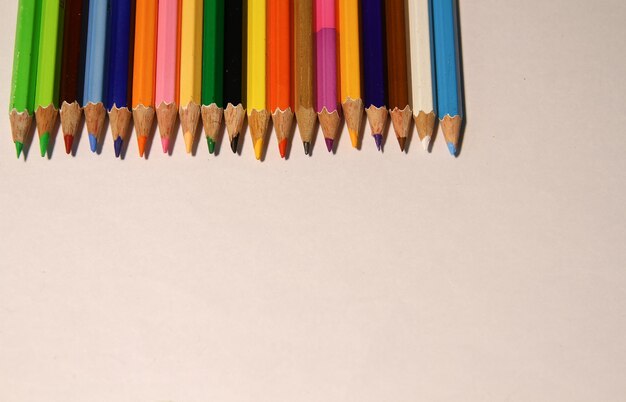 High angle view of multi colored pencils against white background