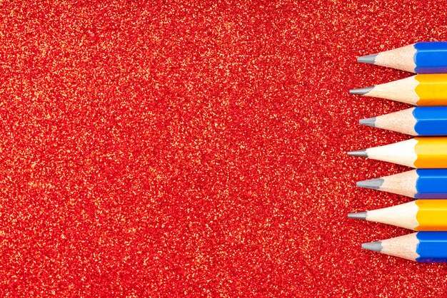 Foto vista ad alto angolo di matite multicolori su sfondo rosso