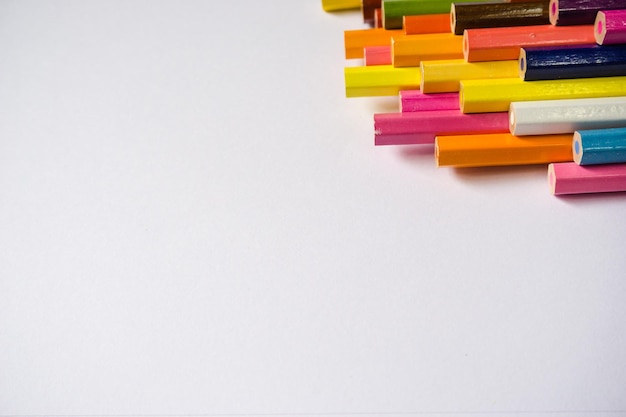 High angle view of multi colored pencils on white background