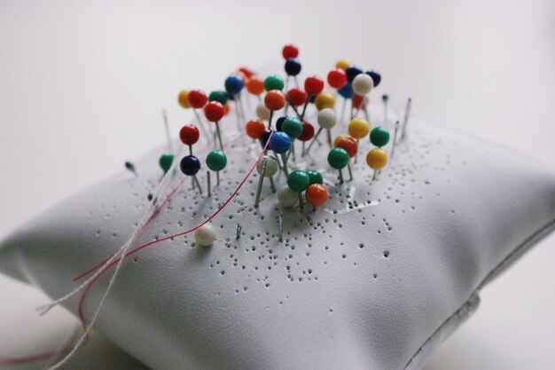 High angle view of multi colored pins on white background