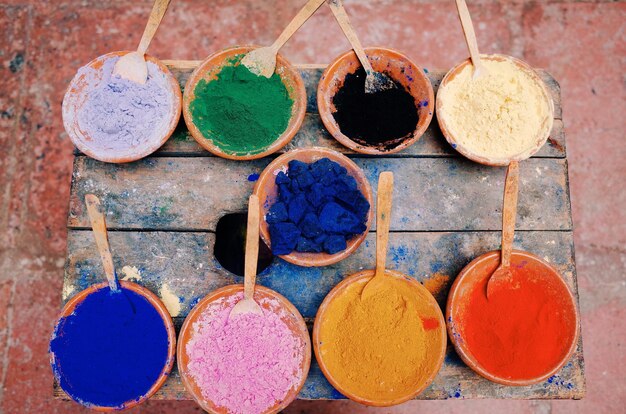 High angle view of multi colored powder paints in bowl on table