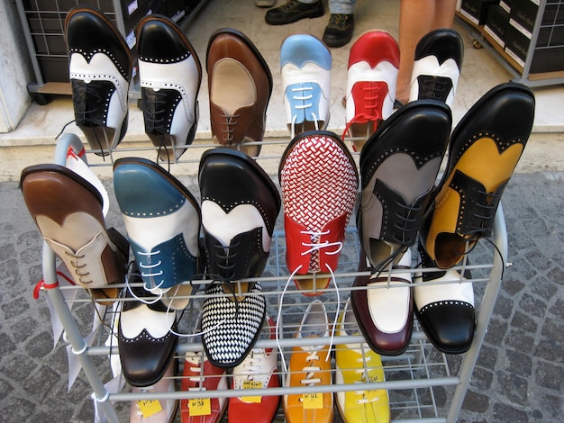 Photo high angle view of multi colored shoes in rack on sidewalk