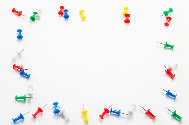 Photo high angle view of multi colored thumbtacks against white background