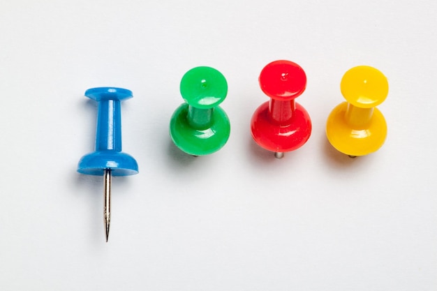 High angle view of multi colored thumbtacks over white background