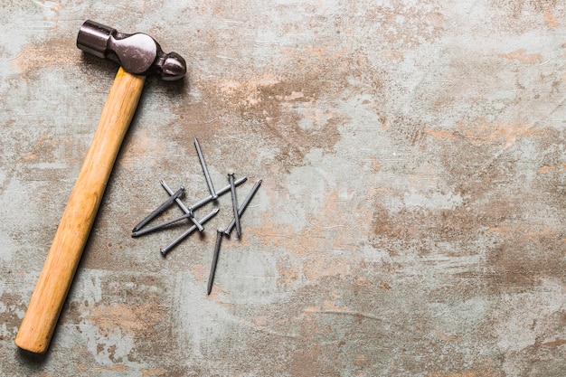 Photo high angle view of nails and hammer on rusty wooden background