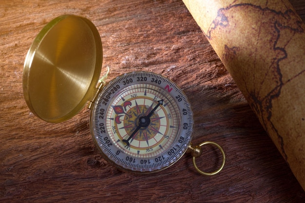 Photo high angle view of navigational compass on wooden table