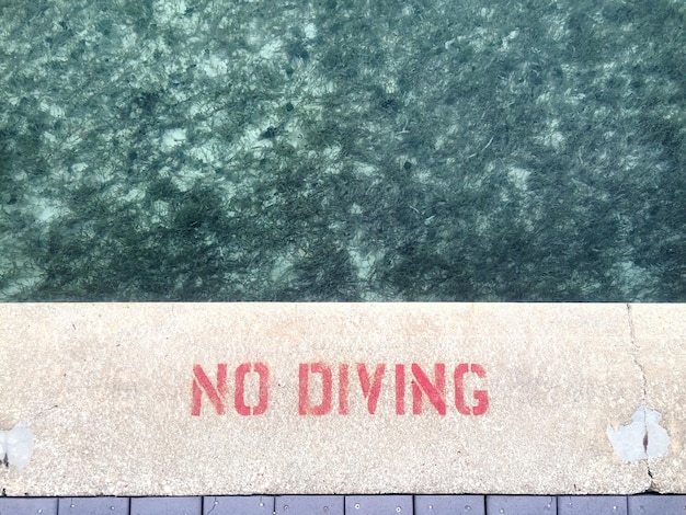 High angle view of no diving sign at poolside