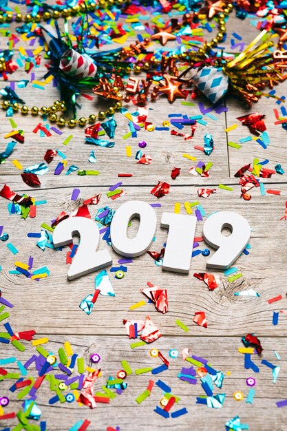 Foto vista ad alto angolo del numero 2019 e dei confetti su un tavolo di legno