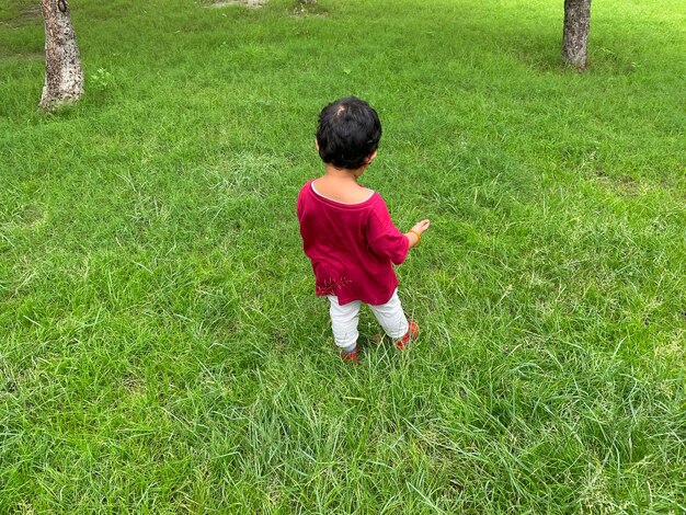 사진 잔디 위 에서 공 을 가지고 놀고 있는 소년 의 높은 각도 의 모습