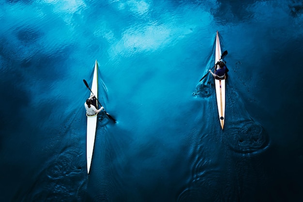 Фото Высокоугольный вид пары, катающейся на байдарке на море