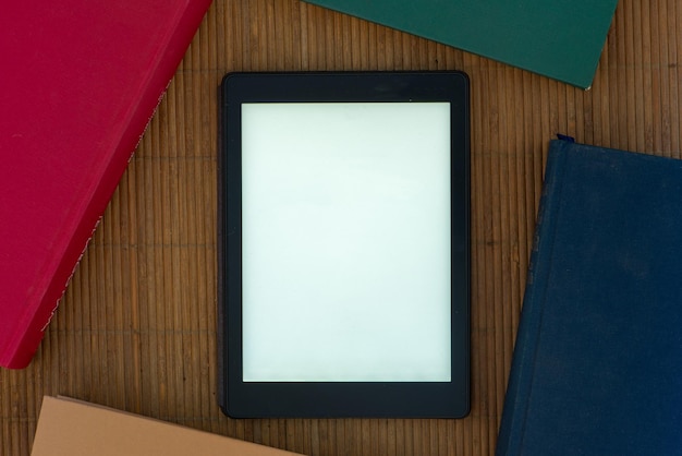Фото Высокоугольный вид цифрового планшета на книгах на столе
