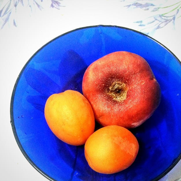 Фото Высокоугольный вид свежих фруктов в голубой чаше