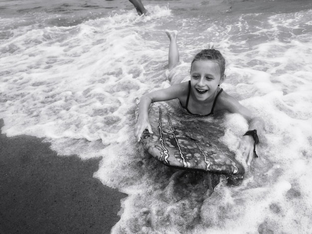 写真 ビーチでサーフボードをしている女の子のハイアングルビュー