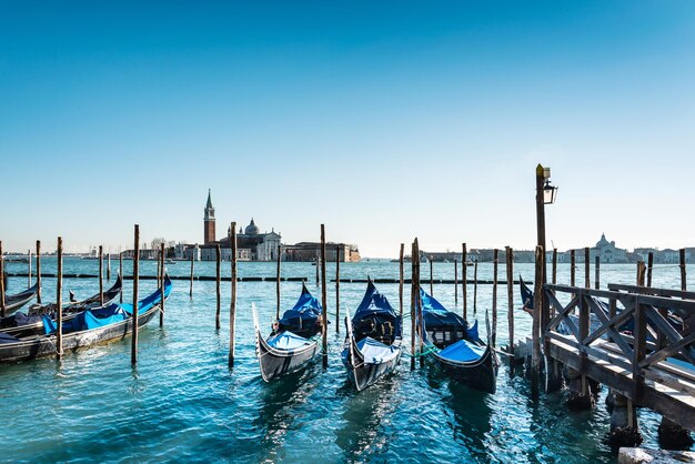 写真 明るい青い空に沿って運河に停泊したゴンドラの高角度の景色