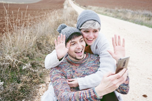 사진 길에 서서 스마트폰으로 셀피를 찍는 행복한 커플의 높은 각도 시각