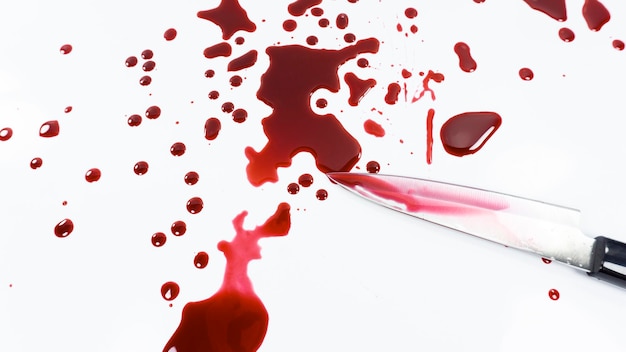 Фото Высокоугольный вид ножа с кровью на белом фоне