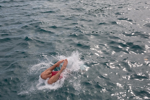 写真 水の中にダイビングする男の高角度の景色