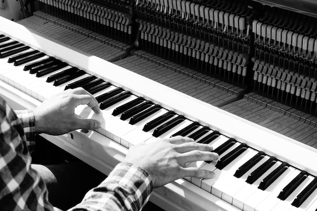 Фото Высокоугольный вид человека, играющего на клавишах фортепиано