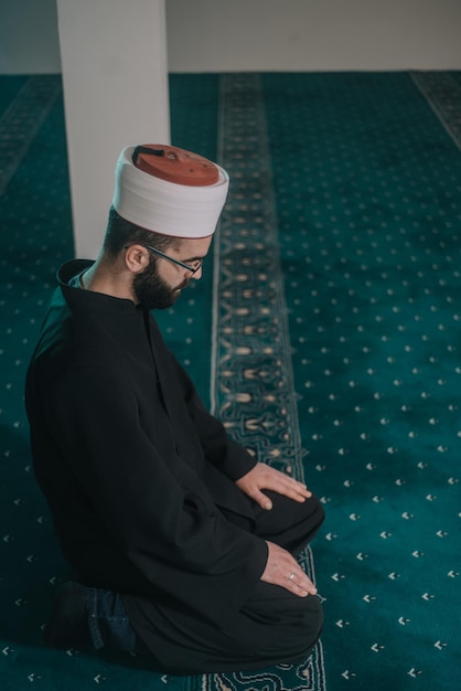 Фото Высокоугольный вид человека, молящегося в мечети