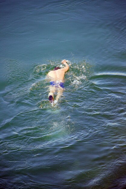 写真 海で泳いでいる男の高角度の写真