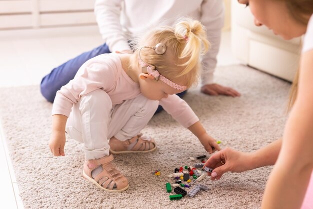 Фото Высокоугольный вид матери, играющей с игрушечными блоками дома