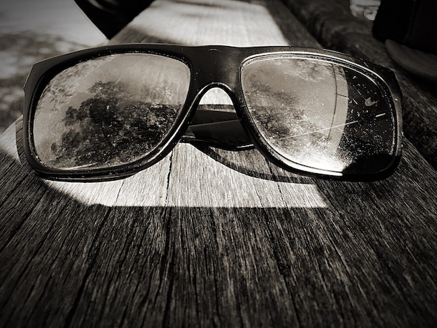 Фото Высокоугольный вид старых солнцезащитных очков на деревянной доске