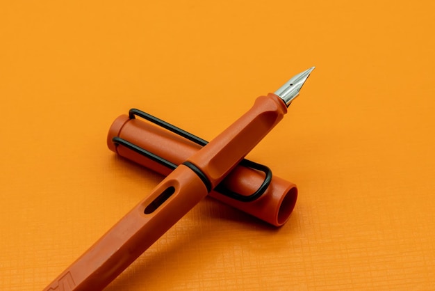 Фото Высокоугольный вид ручки на столе на желтом фоне