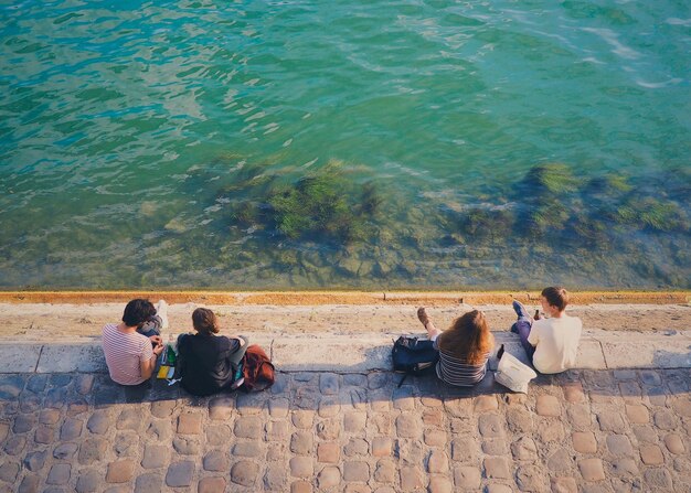 写真 海辺の歩道に座っている人々の高角度の景色