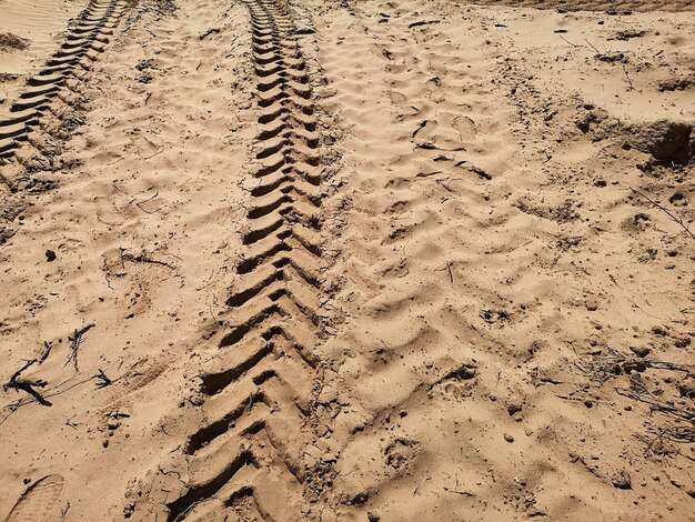 写真 砂上のタイヤの痕跡の高角度のビュー