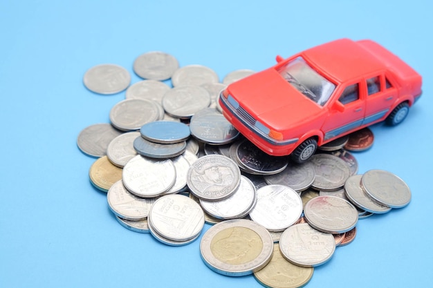 写真 青い背景に硬貨が付いているおもちゃ車の高角度の視点