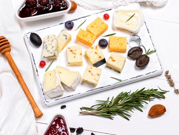 Фото Высокоугольный вид различных сыров и консервов на столе
