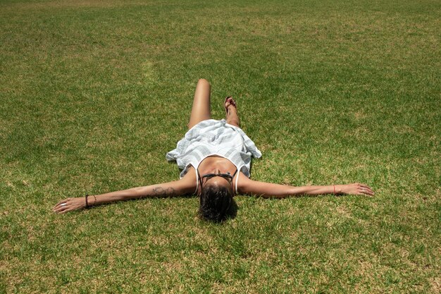 写真 公園の草の上に横たわっている女性の高角度の写真