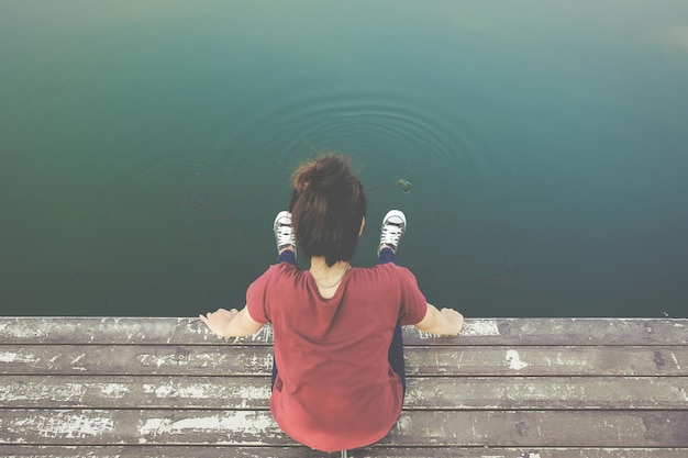 사진 호수 의 기<unk> 에 앉아 있는 여자 의 높은 각도 시각