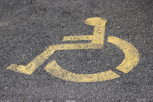 Фото Высокоугольный вид желтого знака для инвалидов на улице