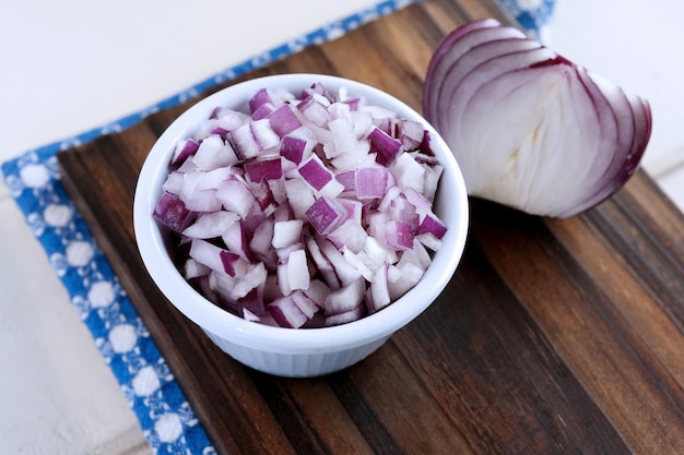 Photo high angle view of onions in bowl on cutting board