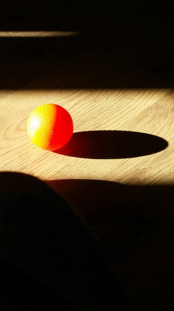 Photo high angle view of orange ball on hardwood floor